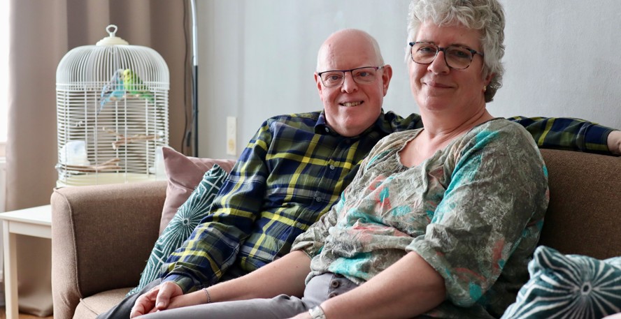  Simone en Martin Franken op de bank in de woonkamer met op de achtergrond een kooi met twee parkieten