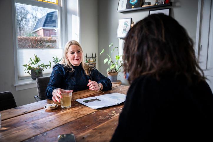 Aan de keukentafel zijn een bewoner en zaakbegeleider Duurzaam Herstel met elkaar in gesprek.