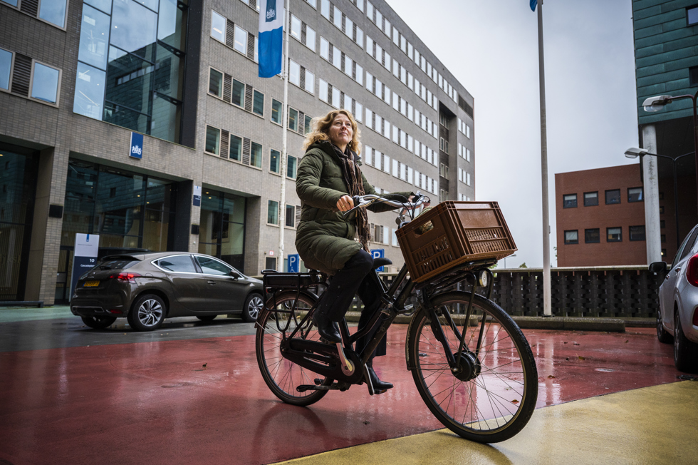 medewerker op de fiets voor het gebouw