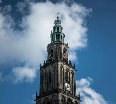 De Martinitoren tegen een half bewolkte blauwe lucht in de stad Groningen