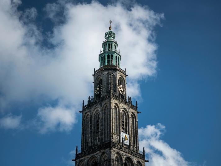 De Martinitoren tegen een half bewolkte blauwe lucht in de stad Groningen