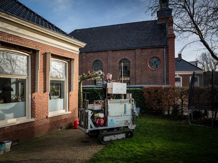 In de tuin van een woning wordt constructief onderzoek uitgevoerd.